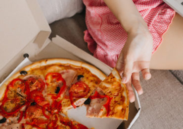 vrouw-ban-eet-pizza-computer
