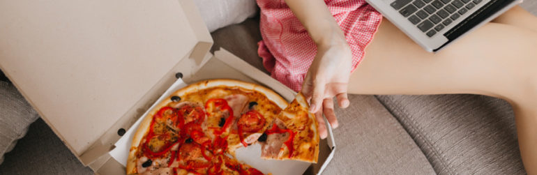 vrouw-ban-eet-pizza-computer